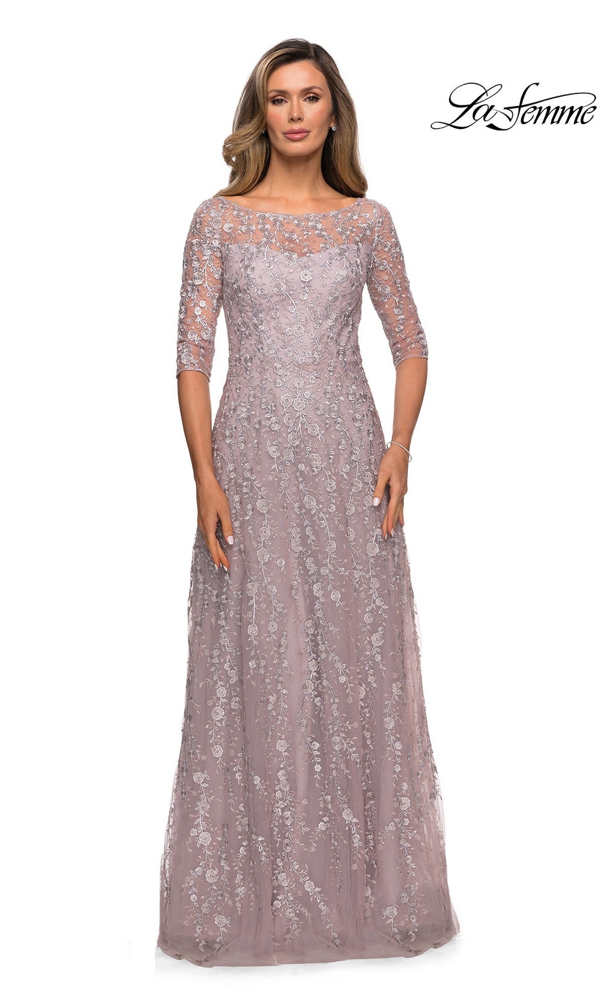 Woman in the Long Formal Dress: La Femme 27981, a floor-length mauve lace gown with elbow sleeves, floral embroidery, and sheer neckline. “La Femme” logo top right.